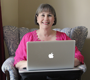 Author Lisa Carter in chair with laptop
