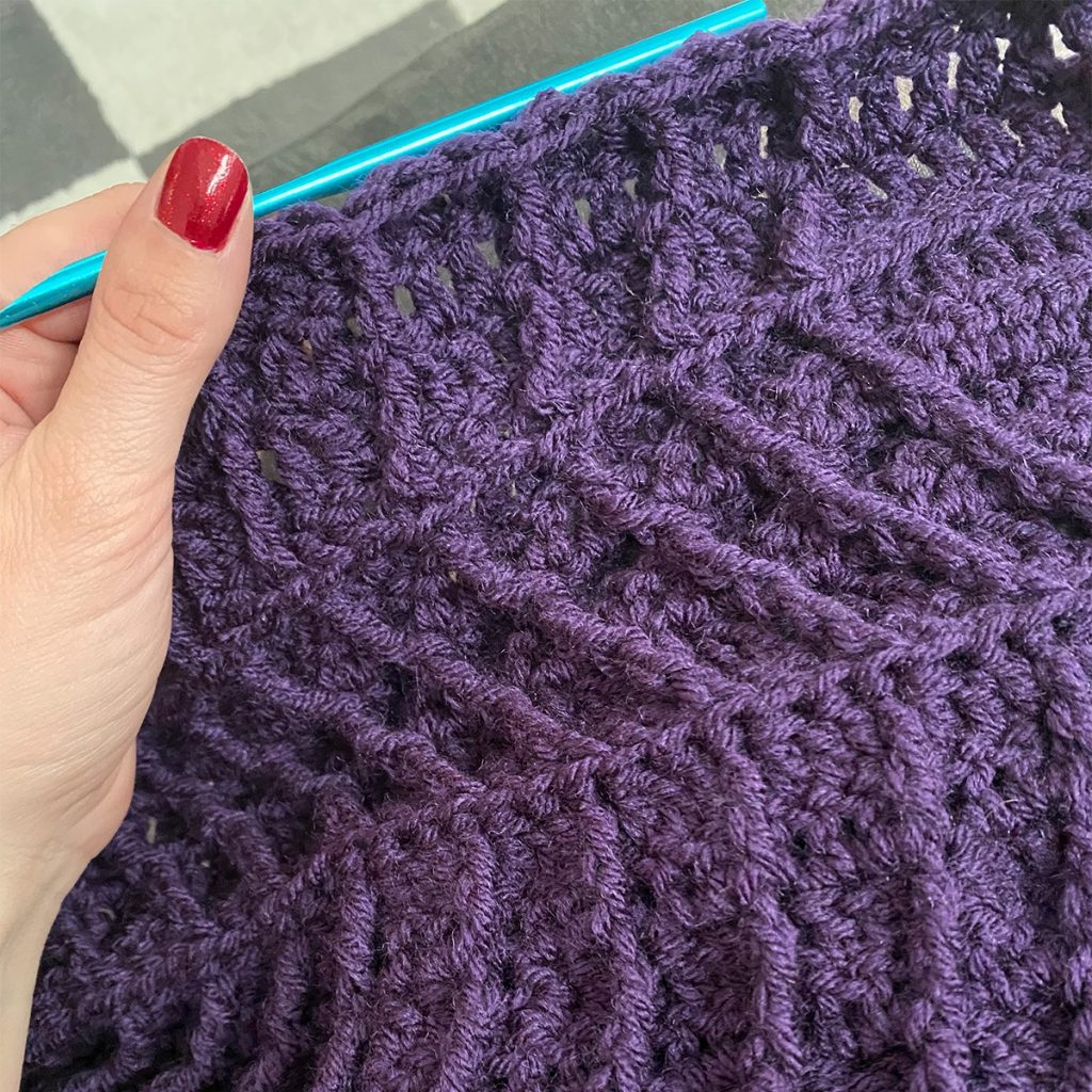 A purple knitted baby blanket