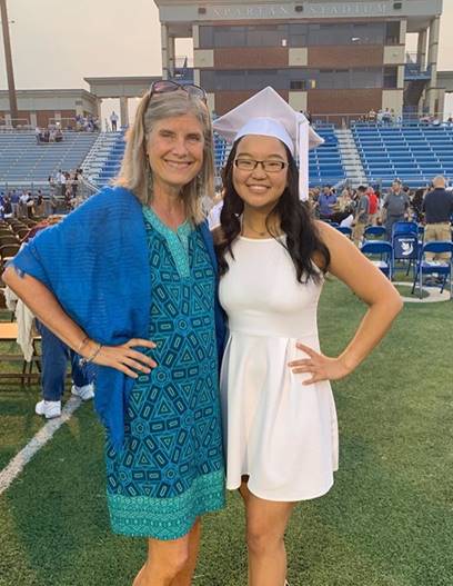 author Lee Tobin McClain with her daughter. The daughter is wearing a white graduation cap.