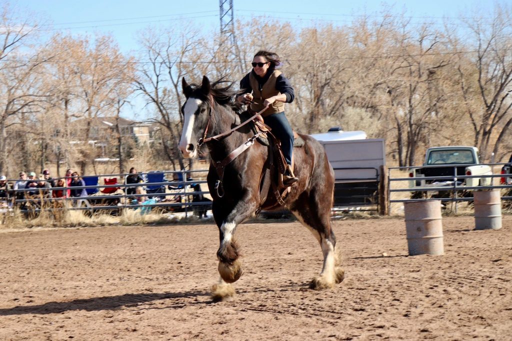 Margaret riding Wallace while a crowd looks on behind a fence.