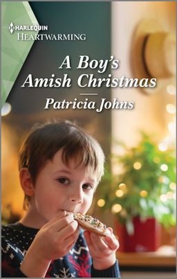 Cover image for A Boy's Amish Christmas by Patricia Johns, featuring a little boy in a Christmas sweater eating a chocolate chip cookie