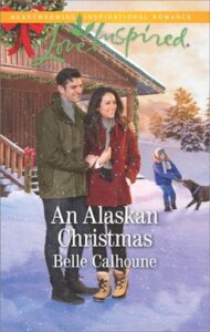 Cover image for An Alaskan Christmas by Belle Calhoune, featuring a man with his arms around a woman. Both are wearing winter jackets and they are standing outside a house in the snow. Behind them is a little boy playing with a dog.