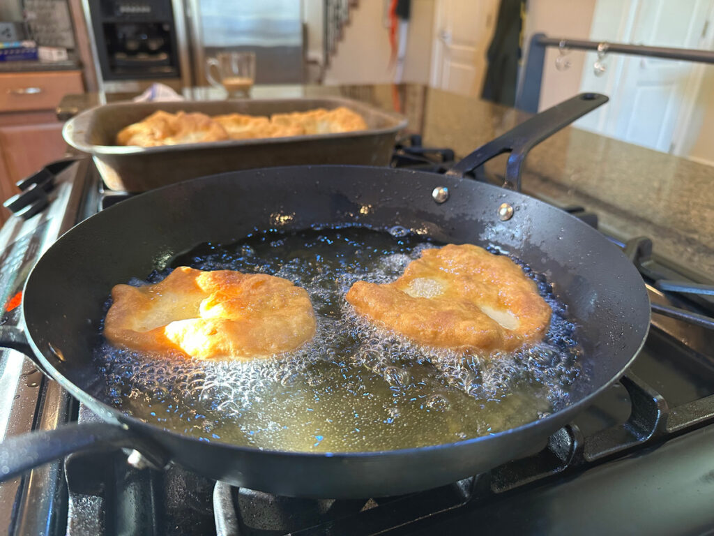 an image of Hojaldras frying in a pan on a stove top