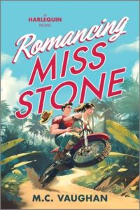 Cover image for ROMANCING MISS STONE by M.C. Vaughan, featuring an illustration of a woman and a man on a motorcycle, surrounded by the jungle. The woman is driving the motorcycle while the man has his hands around her waist. His hat has flown off his head behind him.