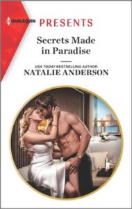 Cover image for Secrets Made in Paradise by Natalie Anderson, featuring a shirtless man and a woman in a white dress kissing on a bed. Outside through the window we can see a beach.