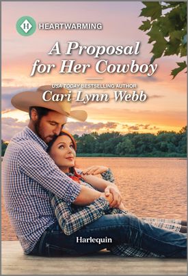 Cover image for A Proposal for Her Cowboy by Cari Lynn Webb, featuring a man and woman sitting on a dock by the water. The woman is leaning back into the man's chest. The man is wearing a cowboy hat.