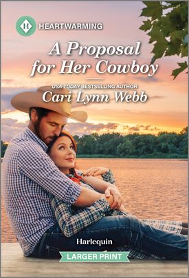 Cover image for A Proposal for Her Cowboy by Cari Lynn Webb, featuring a man and woman sitting on a dock by the water. The woman is leaning back into the man's chest. The man is wearing a cowboy hat.