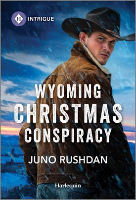 Cover image for WYOMING CHRISTMAS CONSPIRACY by Juno Rushdan, featuring a cowboy standing outside in the wind and snow looking over his shoulder.